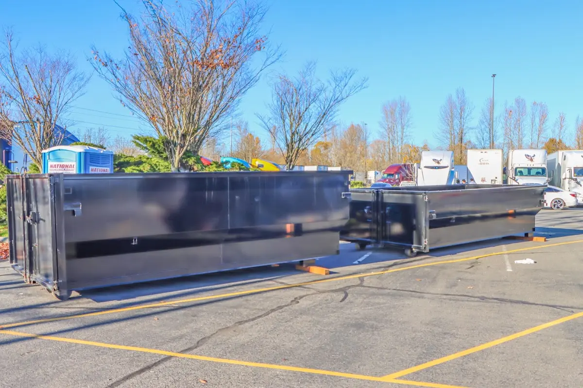 Professional dumpster rental service with roll-off container on residential driveway in Wells